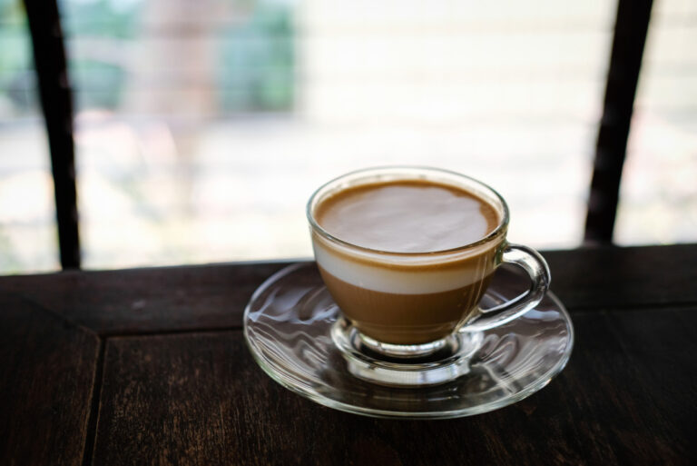 Macchiato: The Definition and Meaning Hot espresso macchiato coffee with milk topping in a glass cup
