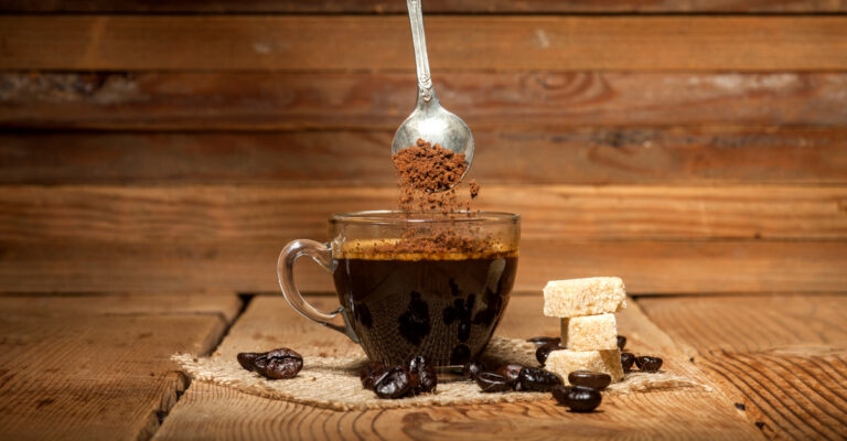 The Best Instant Coffee Brands of the Year glass coffee cup and spoon with instant granulated coffee on old wooden background