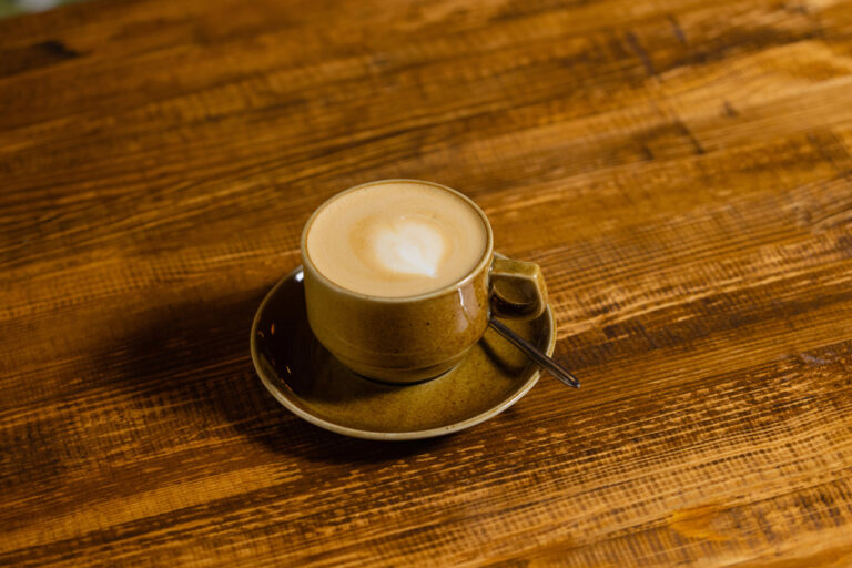The Story of Café au Lait Cups Coffee cup on dark wood table