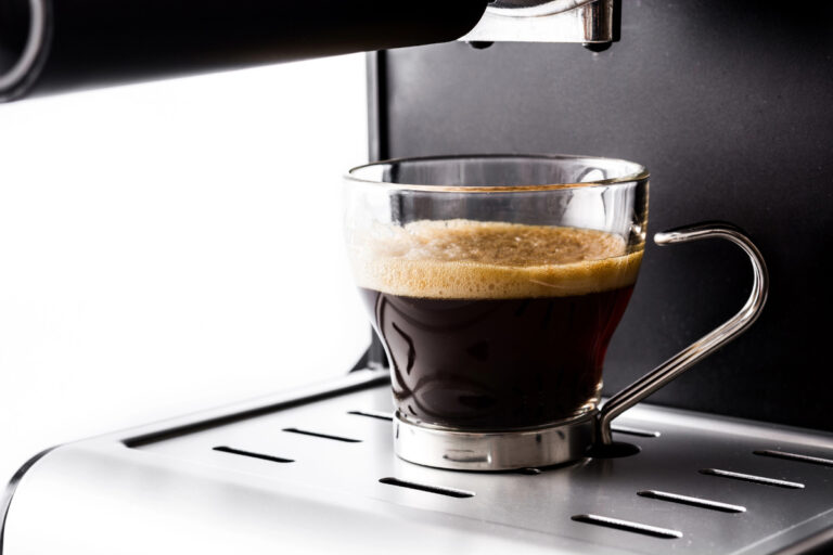 Triple Espresso Shot: The Definition and Meaning fresh coffee with crema in espresso machine on white background