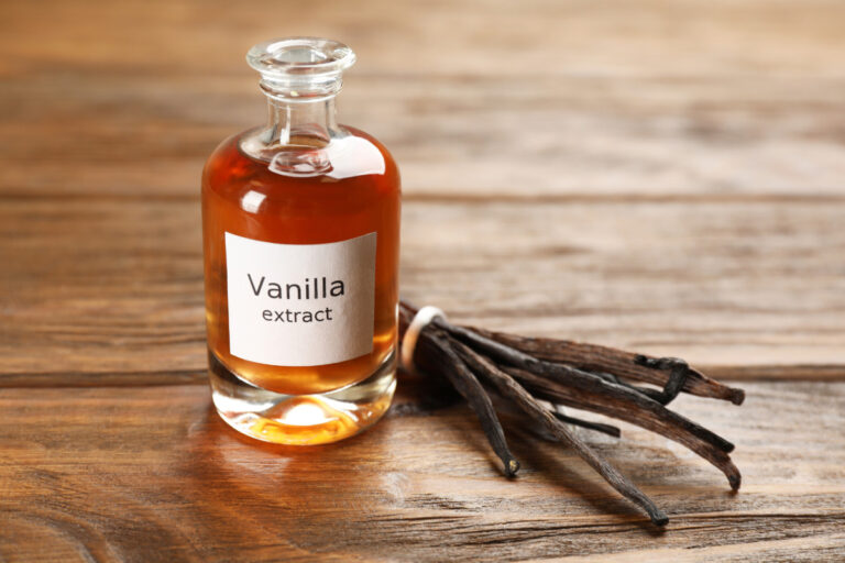 vanilla extract and beans on wooden table