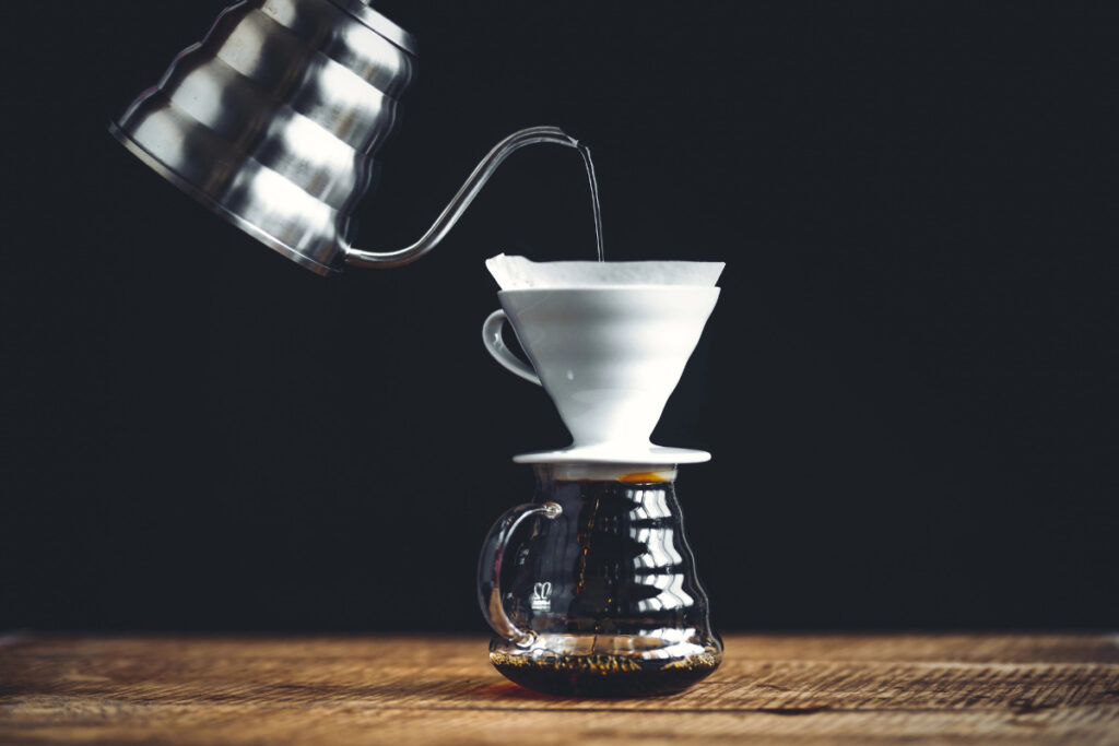 pour over coffee on wooden table with black background