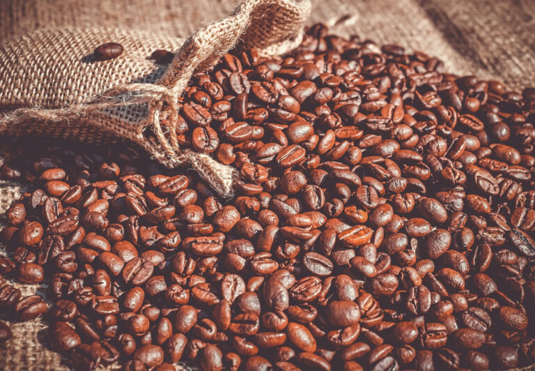 roasted coffee beans flowing from a burlap sack